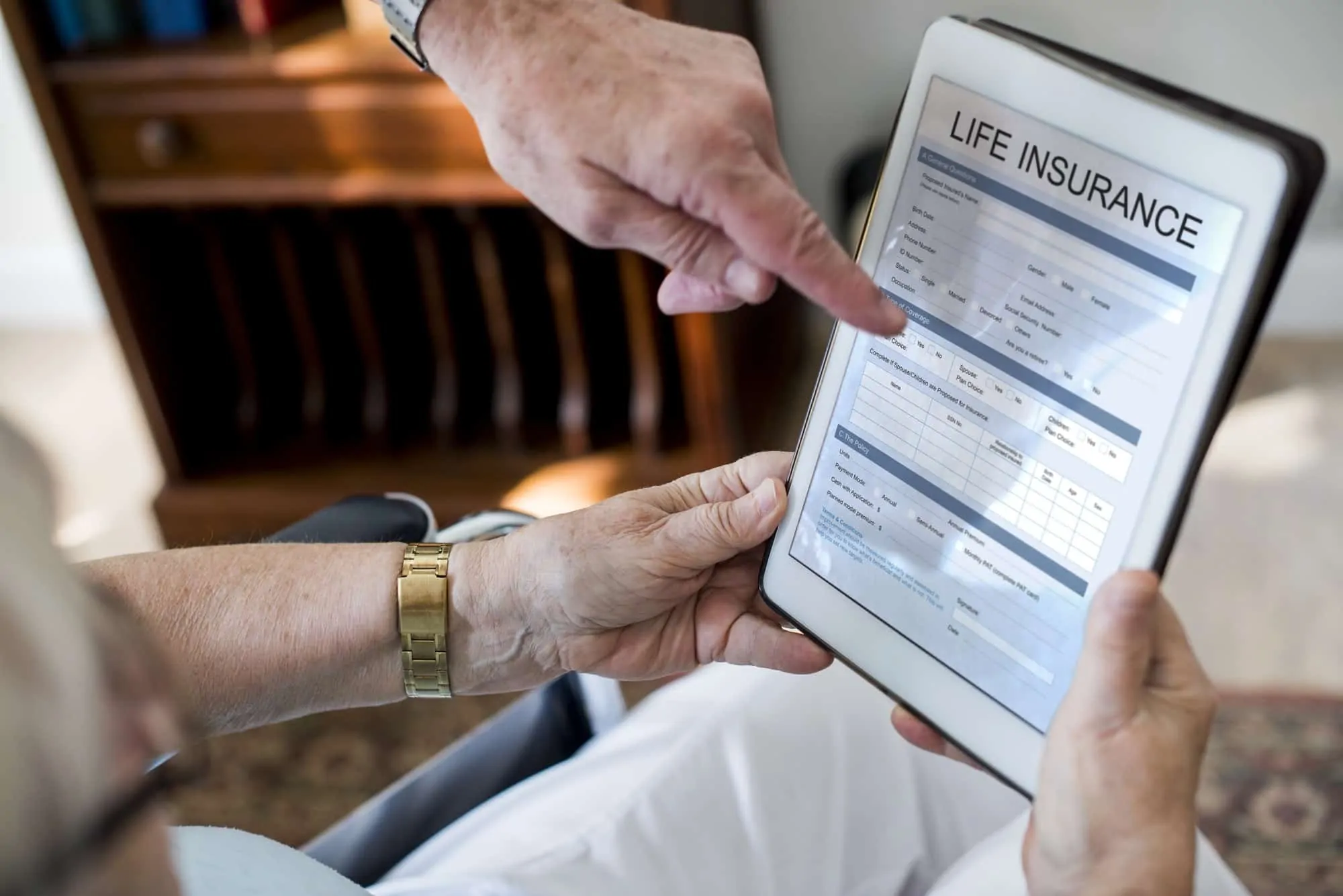 Senior couple reading life insurance form in tablet